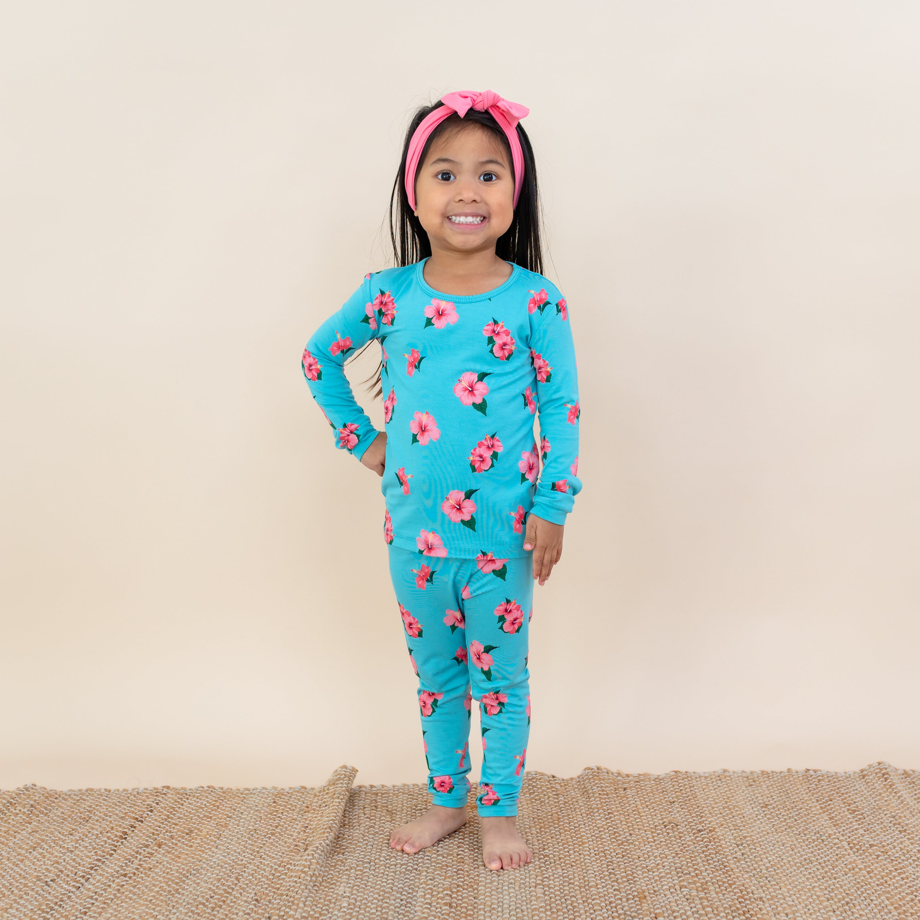 Toddler modeling Kyte Long Sleeve Pajamas in Hibiscus flower print