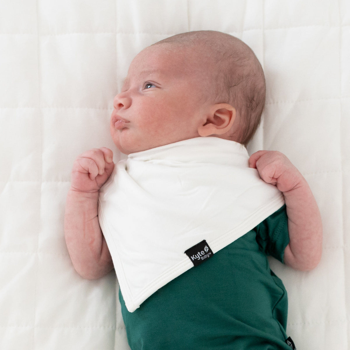 Infant wearing Kyte Baby Bib in Cloud