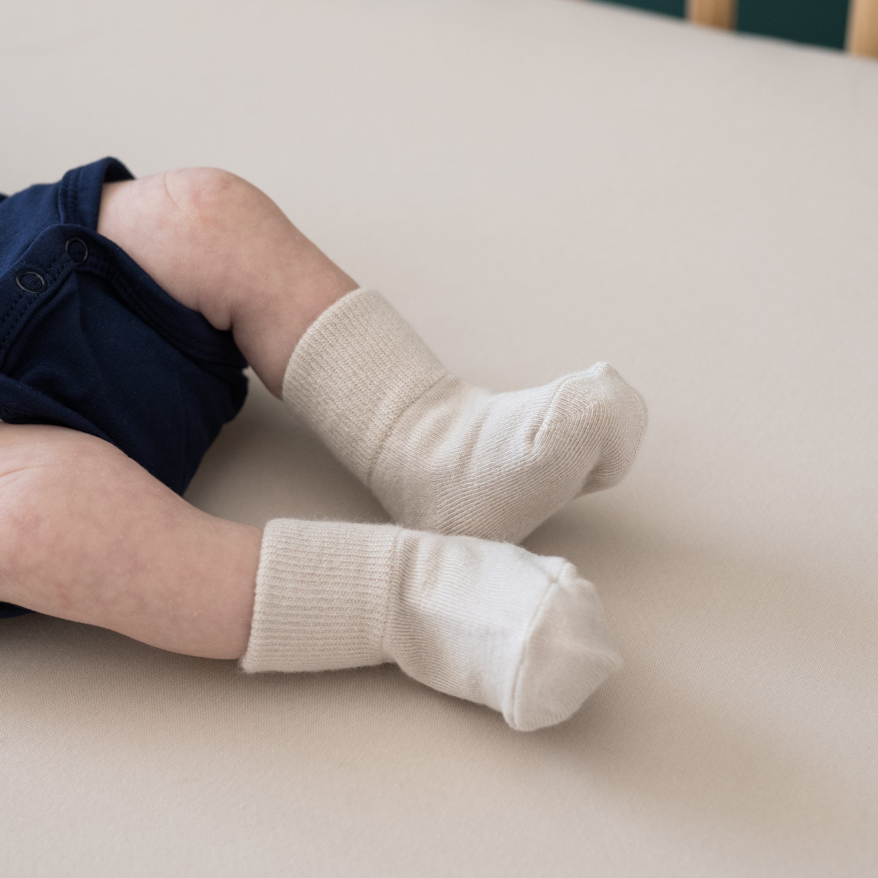 Newborn wearing Kyte Baby Quarter Socks in Neutral Tan