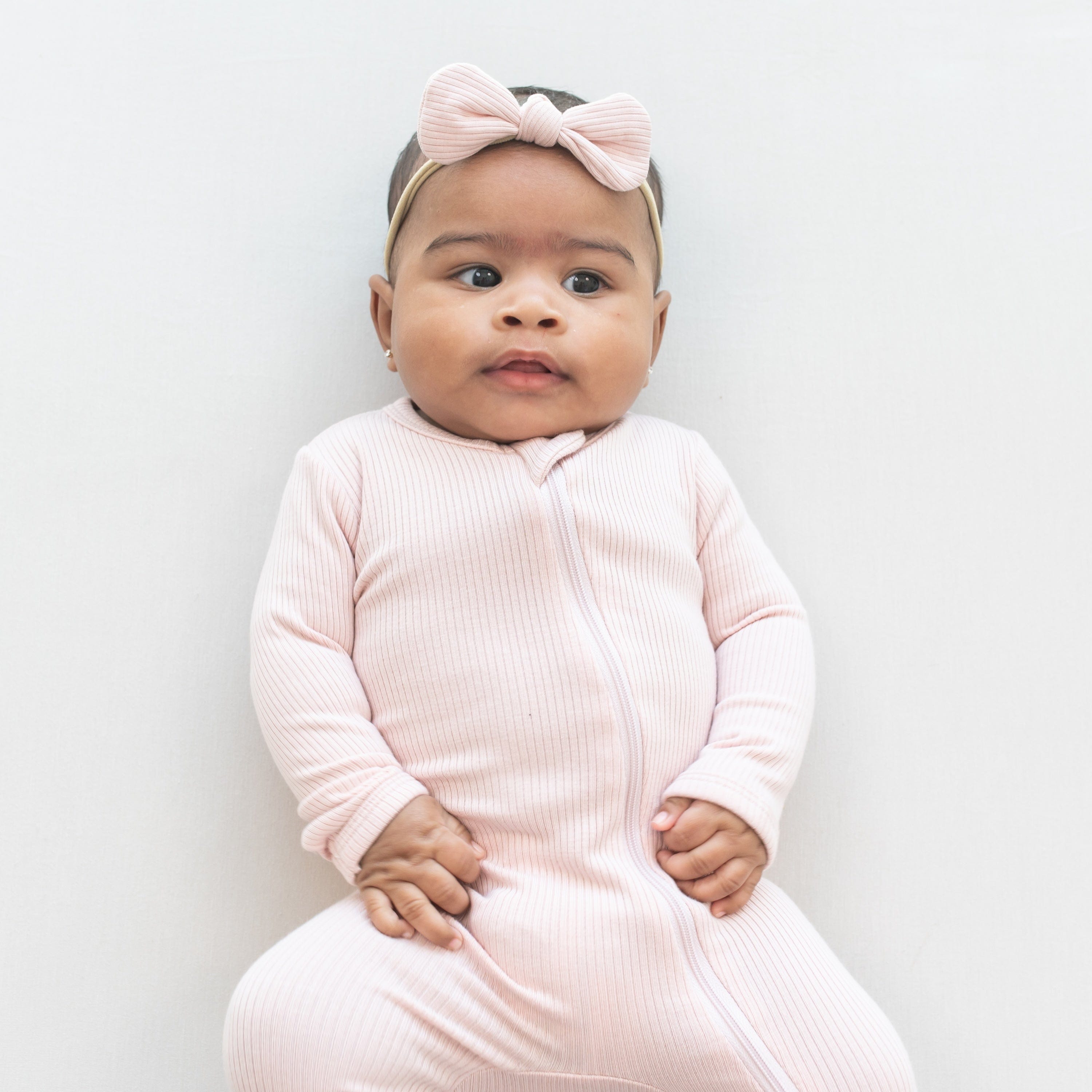 Infant wearing Kyte Baby Ribbed Nylon Bow in Blush